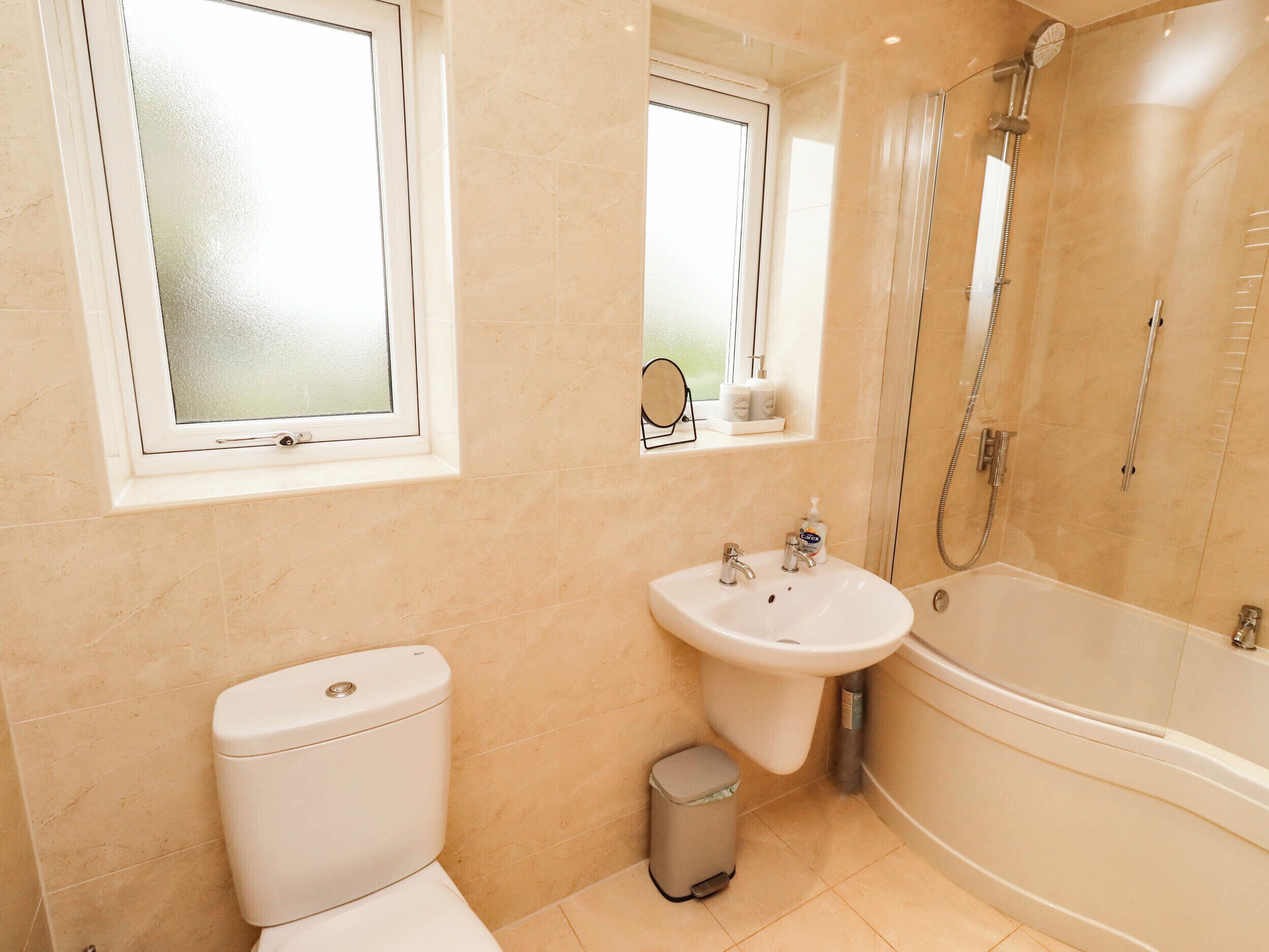 Une salle de bain avec des toilettes, un lavabo et une douche.