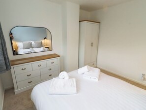 Ein Hotelzimmer mit Bett, Kommode, Spiegel und Kleiderschrank.