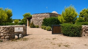 A stone building with a sign indicating it is a historical site. - Il Trullo del Colonnello – Exclusive Historic Stay Near the Sea (Torre Lapillo)