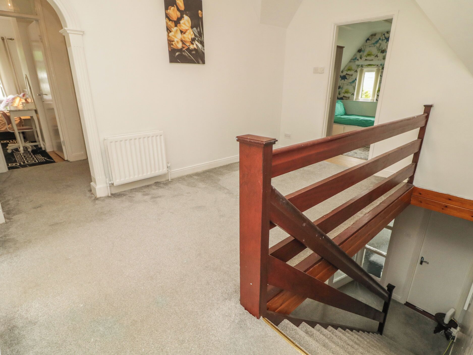 Una escalera con baranda de madera que lleva a una plataforma.