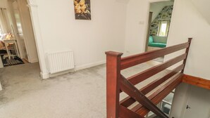 A staircase with a wooden handrail leading to a landing.