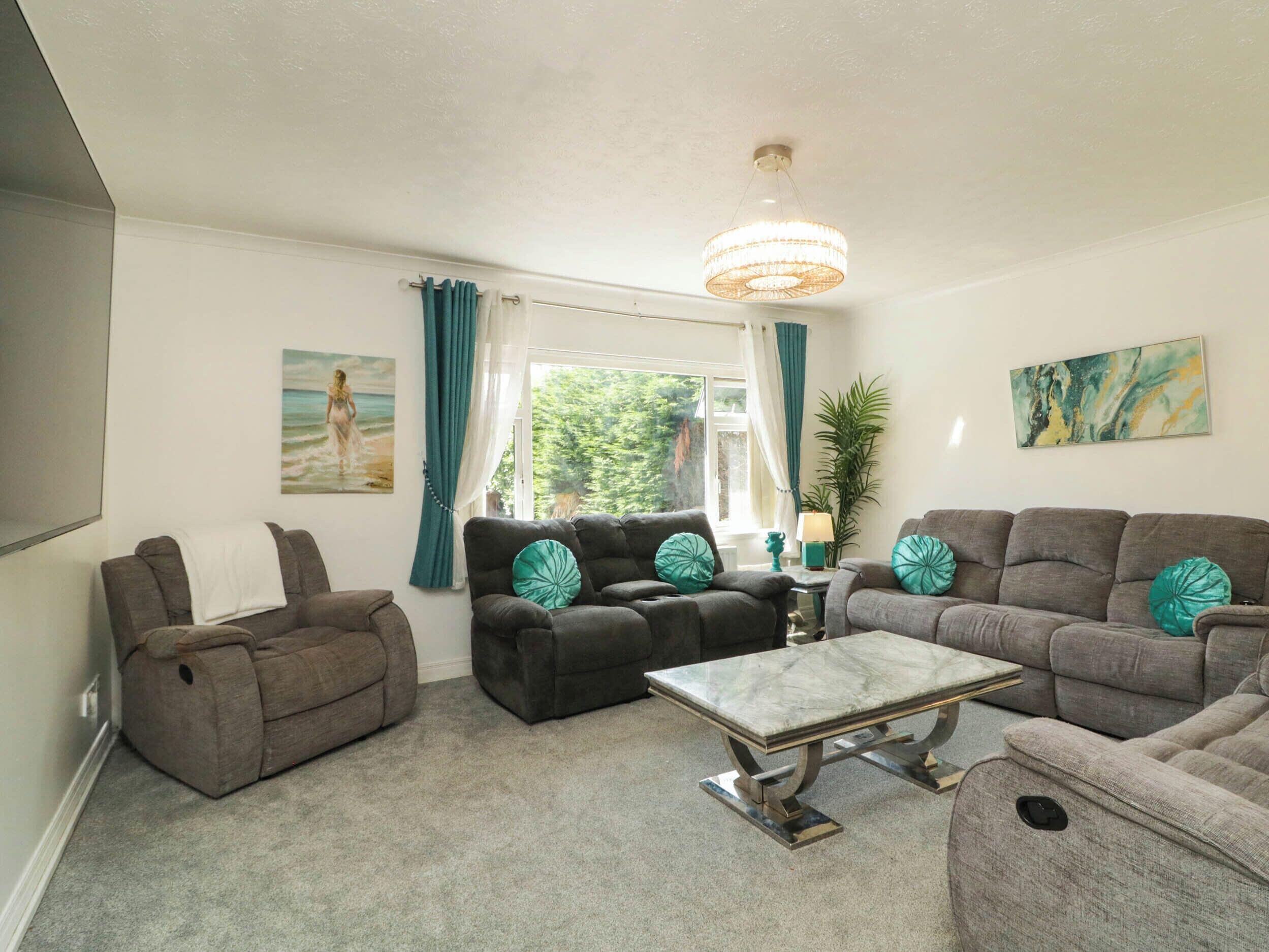 A living room with a sofa set, a coffee table, and a chandelier.