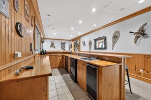 Een keuken met houten kastjes, een vaatwasser en een spoelbak.