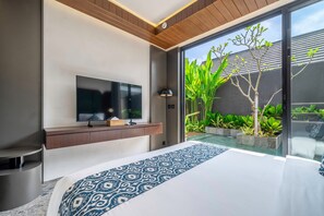 Ein modernes Schlafzimmer mit einem großen Bett, einem flachbildfernseher an der Wand und einer Glastür, die in einen Garten führt.