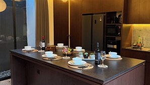 Uma cozinha moderna com uma ilha central, armários de madeira e luminárias pendentes.