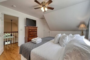 A bedroom with a bed, a dresser, a ceiling fan, and a television. - Cozy 3-bedroom entire home near wineries & waterfalls in Dahlonega, GA (Dahlonega)