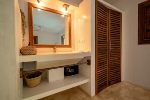 Une salle de bain avec un miroir, un lavabo, un porte-serviettes et une porte en bois.