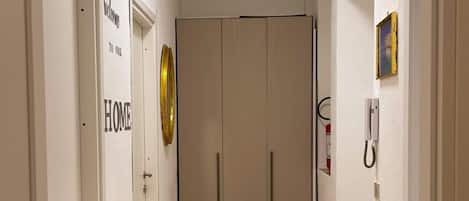 A hallway with a light fixture, a fire alarm, and a door labeled 'HOME'.