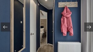 A hallway with a coat rack, a door, and a radiator. - Thurston Manor, 3 Bedroom Caravan (Dunbar)