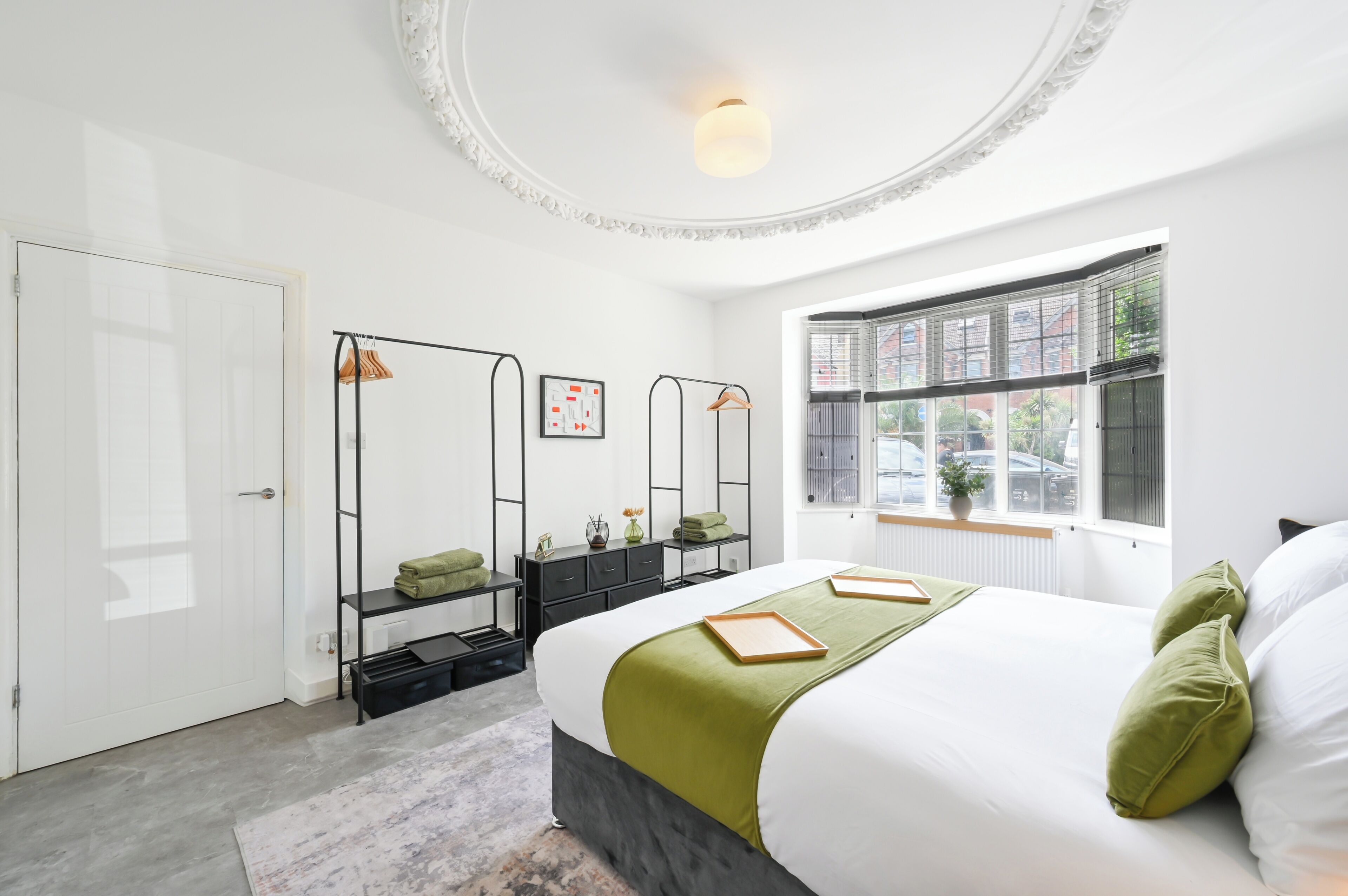 Un dormitorio moderno con una cama, un armario, un espejo y una ventana.
