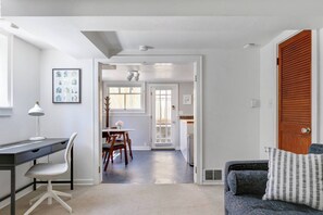 Een modern interieur met een bureau, stoel, eettafel en een bank.