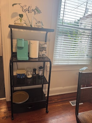 A kitchen area with a coffee station, a paper towel holder, a spice rack, and a glass carafe on a black metal shelf. - Experience Baltimore’s charm city charm neighborhood by John Hopkins Bayview (Baltimore)