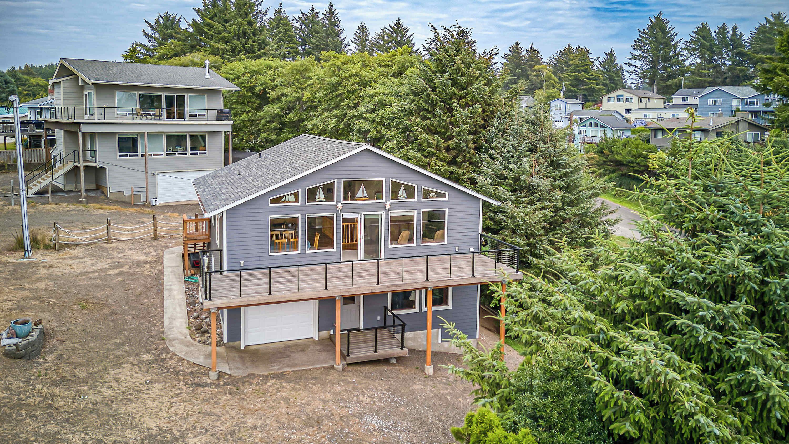 A two-story house with a balcony, a garage, and a driveway.