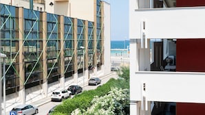 Un edifici modern amb façana de vidre i vista al mar.