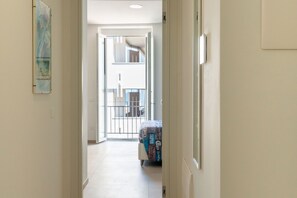 A hallway leading to a balcony with a bed and a suitcase. - Alba Chiara Guest House - Sea View by BarbarHouse (Bari)