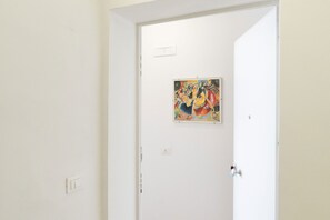 Eine weiße Tür mit einem farbenfrohen Gemälde darüber an der Wand.