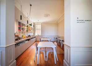 A breakfast area with a white table and chairs, a counter with kitchen items, and a window with natural light.