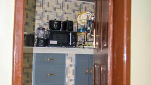 Cocina con armarios azules, un microondas y una cafetera.
