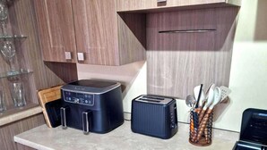 A kitchen with a built-in toaster, a coffee maker, and a utensil holder on the countertop. - A Stunning High Spec 6 Berth Caravan by the sea (Rhyl)