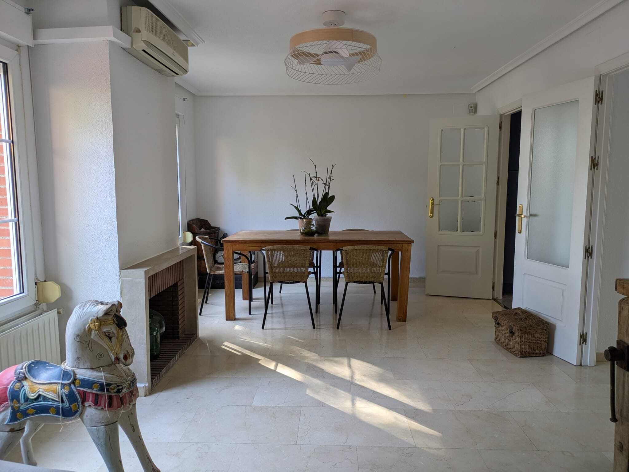 A dining area with a table and chairs, a fireplace, and a decorative horse sculpture.