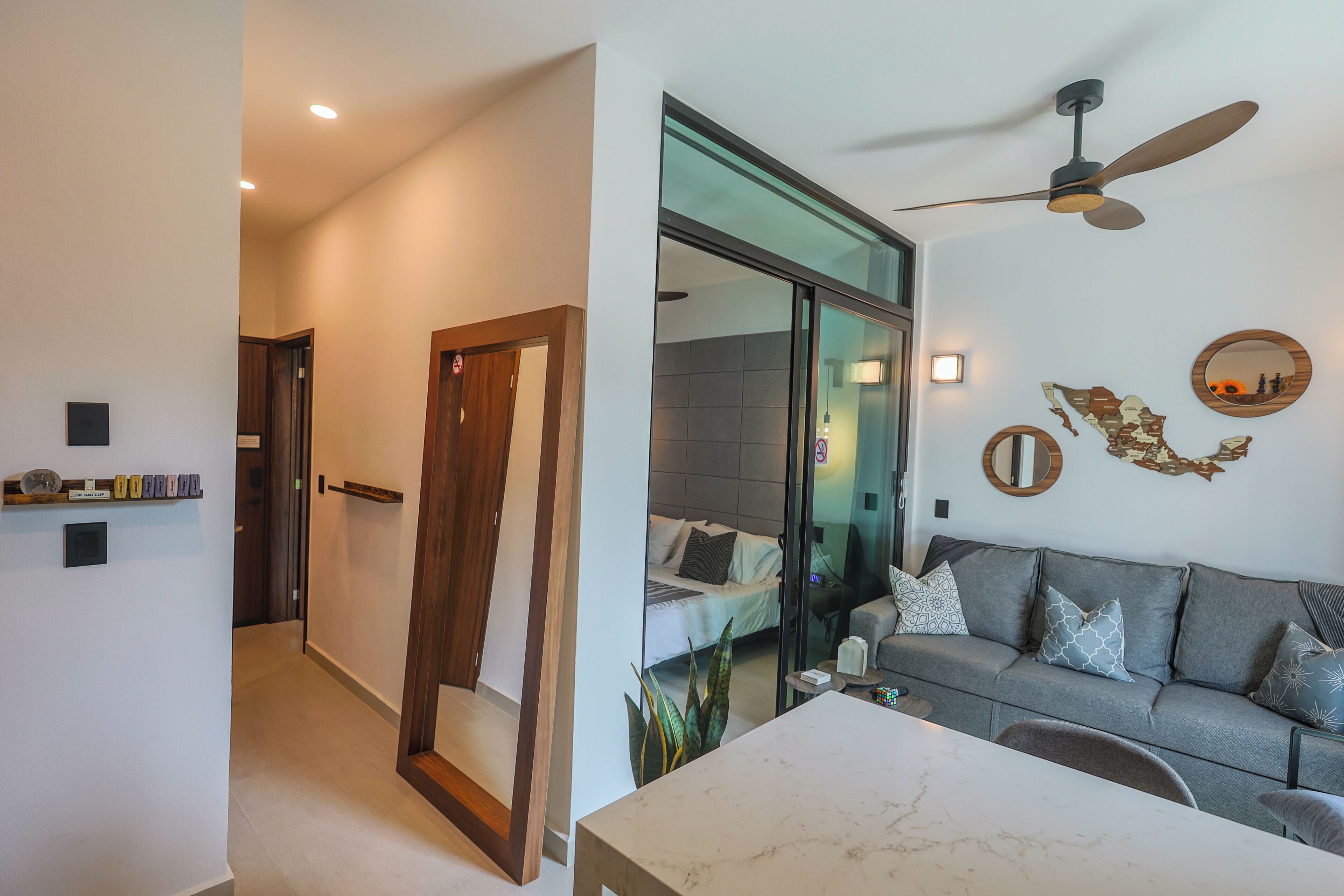Un salon moderne avec un canapé, une table basse et un ventilateur de plafond.