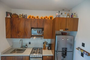 A kitchen with wooden cabinets, a built-in microwave, a stainless steel refrigerator, and a gas stove. - La Mexicana, Puerto Vallarta—Romantic Zone, within walking distance of Los Muertos Beach (Puerto Vallarta)