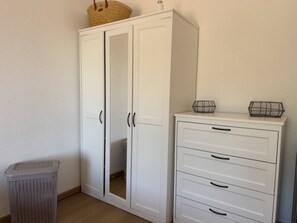 A white wardrobe with a mirrored door and a small basket on top. - Ideal vacation home with a pool, teak deck, and ocean view in Valcros (La Londe-les-Maures)