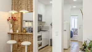 A modern kitchen with white cabinets, a built-in oven, and a stainless steel sink. - Bairro Alto Stylish II by Homing (Lisbon)