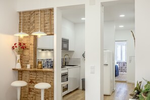 A modern kitchen with white cabinets, a built-in oven, and a stainless steel sink. - Bairro Alto Stylish II by Homing (Lisbon)