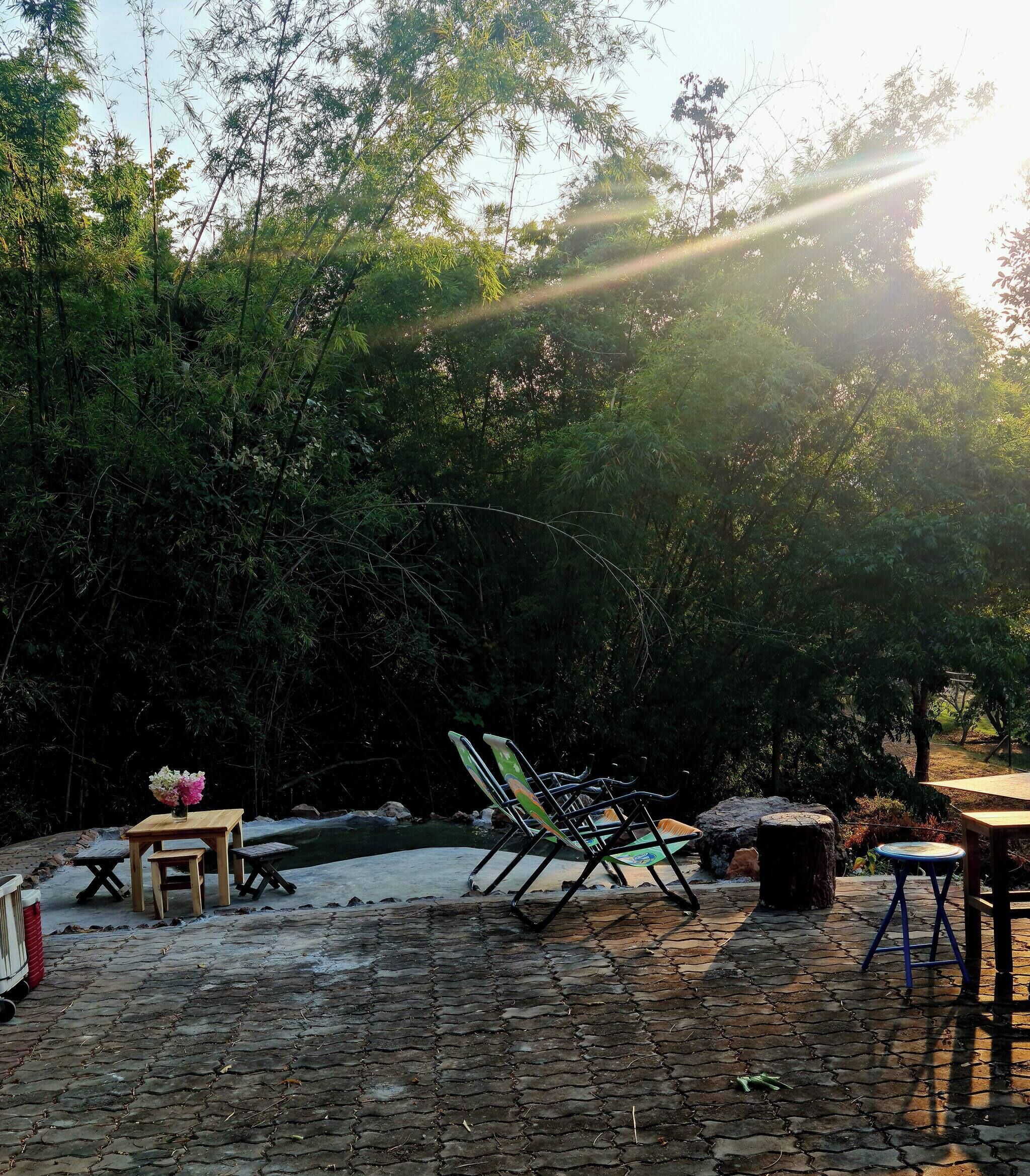 Un espace extérieur aménagé avec une table, des chaises et un petit jardin.
