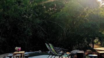 Un espace extérieur aménagé avec une table, des chaises et un petit jardin.