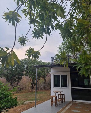 A small house with a patio, a table, and two chairs.