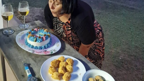 A woman seated at an outdoor table with a cake, drinks, and food. - Mountain Front Family Home Big Balcony For 4 Rare Birds, Bikes (Kaeng Krachan)