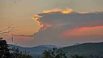 A landscape with a mountain range and a cloudy sky.