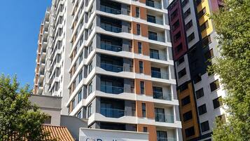 A multi-story building with a dental clinic on the ground floor, featuring a sign with a smiling patient and the name 'Dentica.'