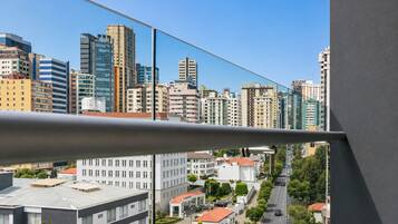 A cityscape with modern buildings, a clear sky, and a street with cars.