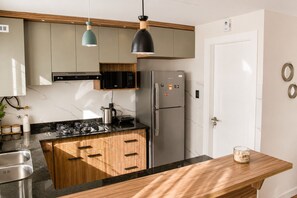 Una cocina moderna con una isla central, electrodomésticos de acero inoxidable y armarios de madera.