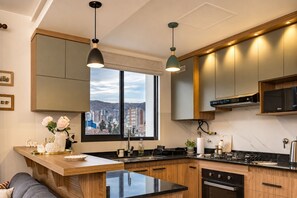 A modern kitchen with a large window, wooden cabinetry, and a central island.