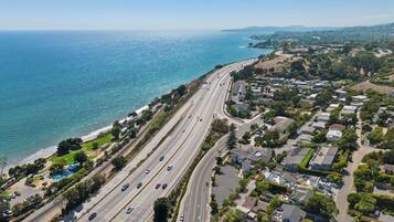 Eine Küstenstraße mit mehreren Fahrstreifen, angrenzenden Wohngebieten und einem Strand.