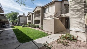 A residential building with a covered patio, a well-maintained lawn, and a clear sky. - Scottsdale Stay  Near Spring Training Games (Scottsdale)