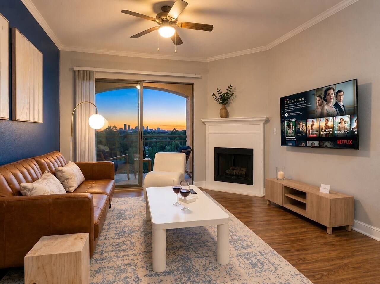 A living room with a sofa, coffee table, fireplace, TV, and a view through a glass door.