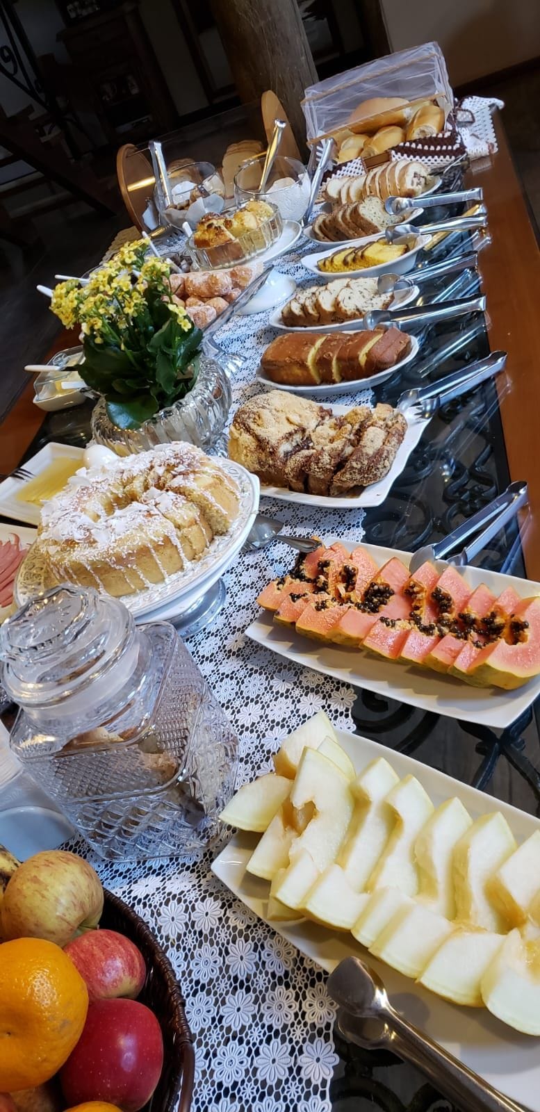 A buffet table with various food items and utensils.