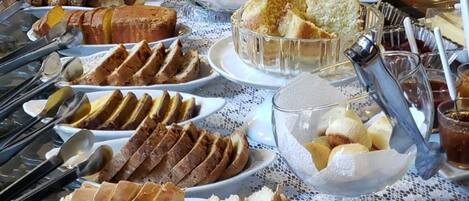 Ein reichhaltiges Buffet mit verschiedenen Speisen, darunter Brot, Gebäck und Früchte.