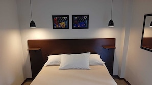 A neatly made bed with white linens in a hotel room. - Refúgio das araucarias (Canela)