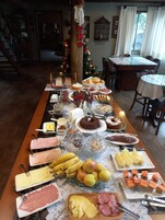 A buffet table with various food items and a Christmas tree in the background.
