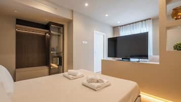 Una camera d'albergo con un letto, una televisione, un armadio e una finestra con tende.