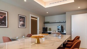 A modern conference room with a marble table, framed artwork on the walls, and a coffee station. - Ardito White Coast Collection (Polignano a Mare)