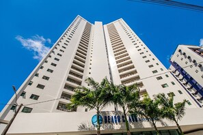 A high-rise building with multiple floors, a clear blue sky, and palm trees in the foreground. - Studio in Condo. w/ Pool and City View Bcm0403 (Recife)