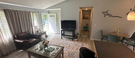 A living room with a ceiling fan, leather sofas, a coffee table, and a TV.