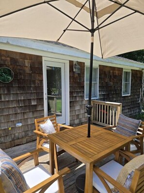 A wooden deck with a table and chairs, a pergola with an umbrella, and a house with a shingled exterior. - Private 2BR Bungalow • Deck & Grill • Near Newport & RI Coastline  (North Kingstown)